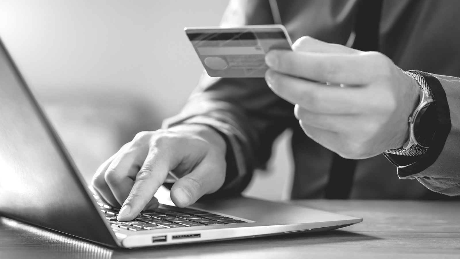 laptop and person holding credit card